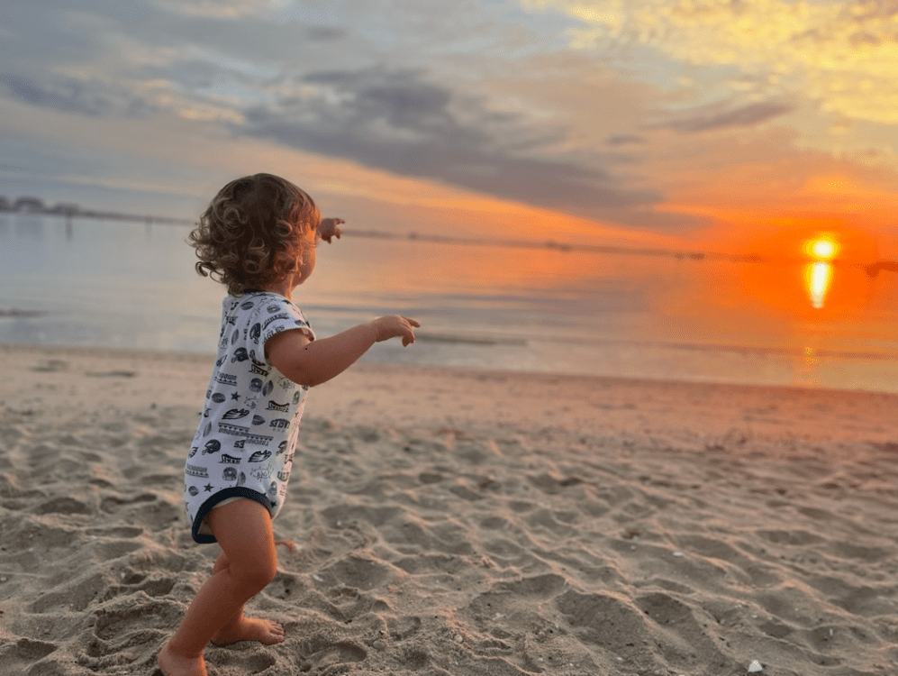 Joe's 2-year-old grandson Aiden, strolling on the sand, and enjoying the sunset over the ocean.