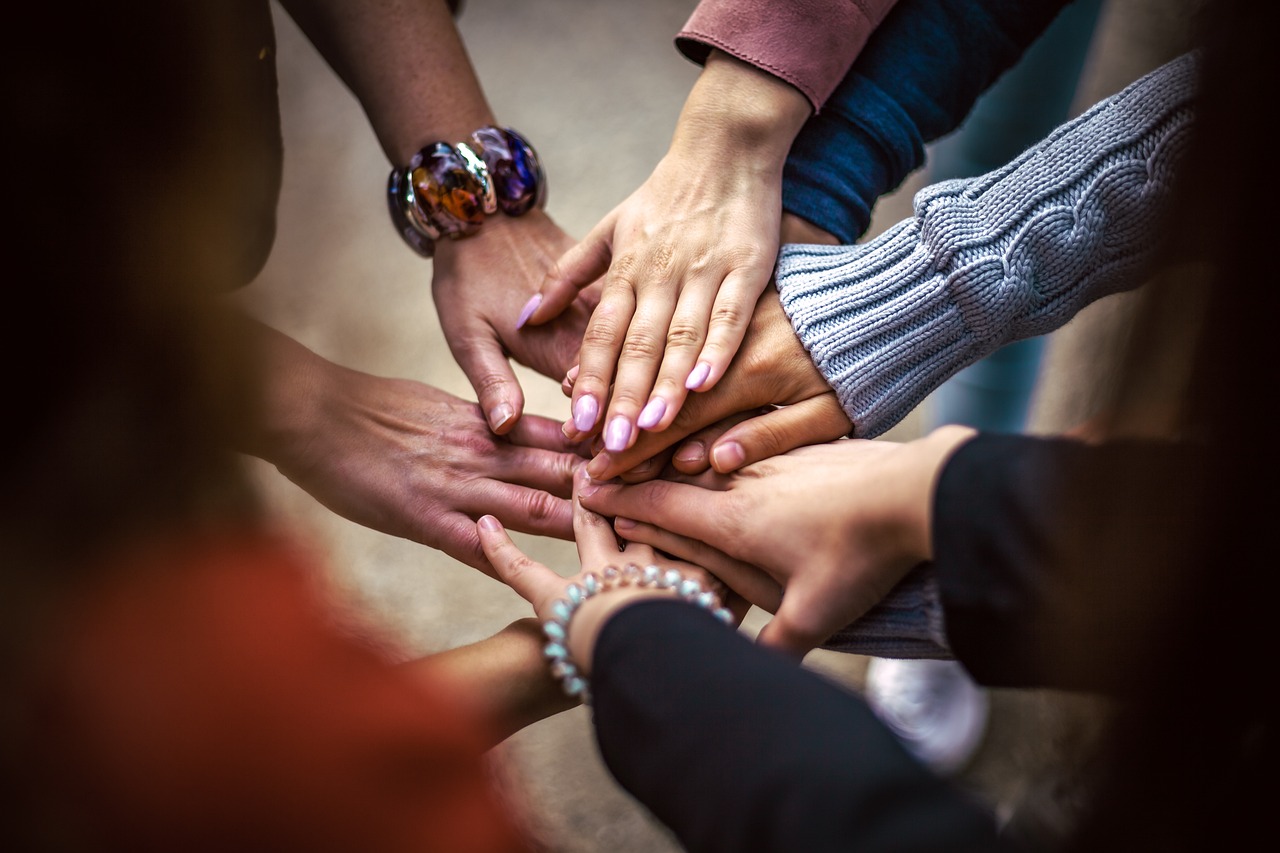A group of people placing their hands together in a circle